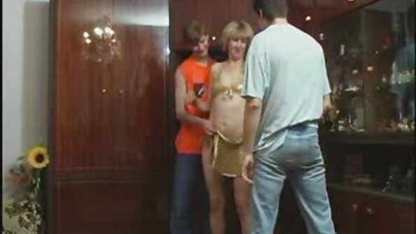 Μια μεγαλόστομη μελαχρινή που λατρεύει τον κόκορα κάθεται σε μια χοντρή στο κρεβάτι